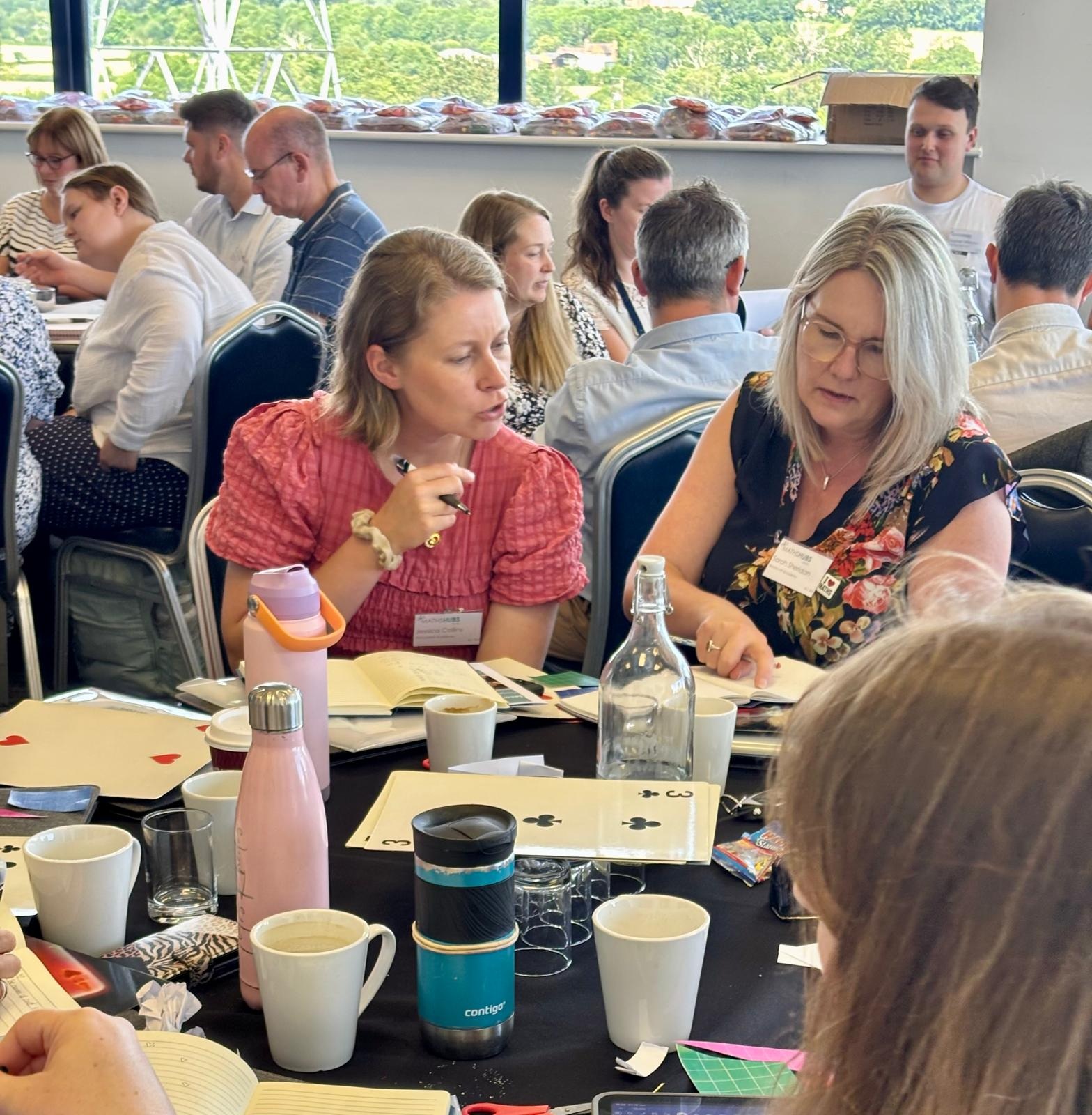 Photo of MathsFest delegates working together at tables