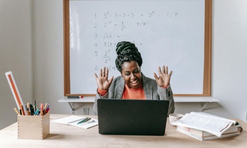 Image of teacher at desk